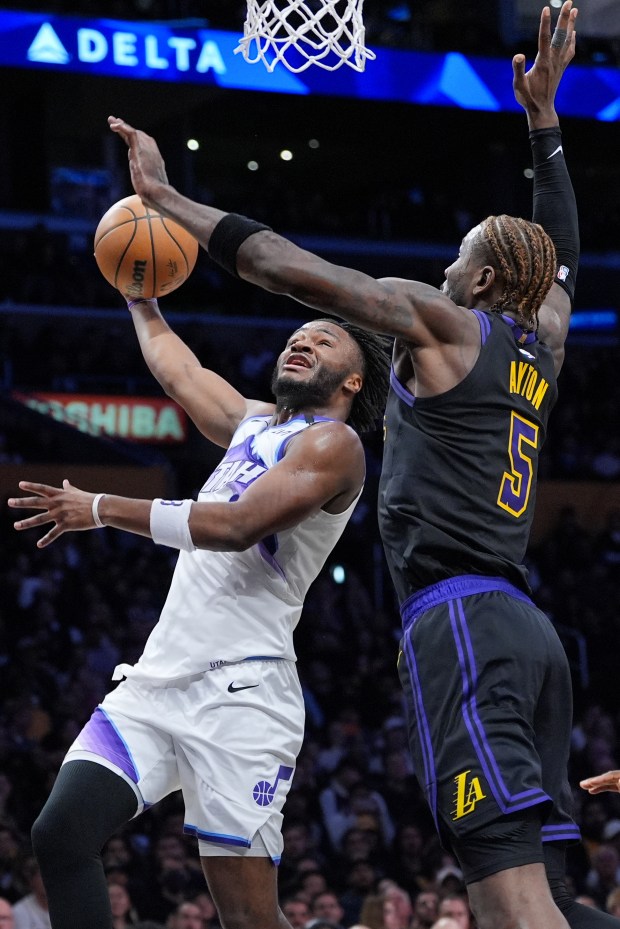 Utah Jazz guard Isaiah Collier, left, is defended by Lakers...