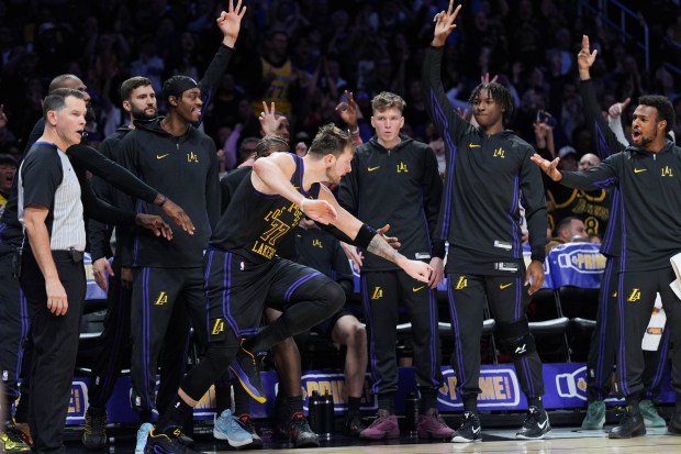 Lakers star Luka Doncic (77) and teammates celebrate a 3-point...