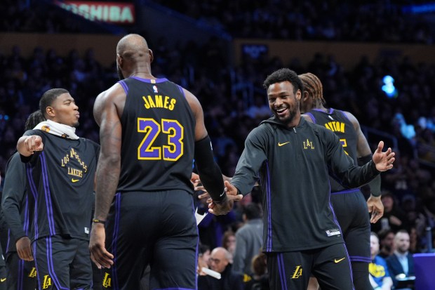 Lakers star LeBron James (23) is greeted by guard Bronny...