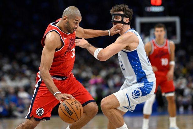 Clippers forward Nicolas Batum, left, is defended by Orlando Magic...