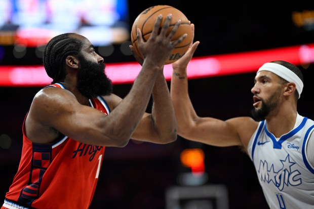 Clippers guard James Harden goes up to shoot in front...