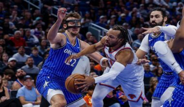 New York Knicks guard Jalen Brunson, right, passes the ball around Orlando Magic forward Franz Wagner during the first half of an NBA basketball game, Saturday, Nov. 22, 2025, in Orlando, Fla. (AP Photo/Kevin Kolczynski)