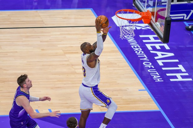 Lakers forward LeBron James, center, dunks the ball during the...