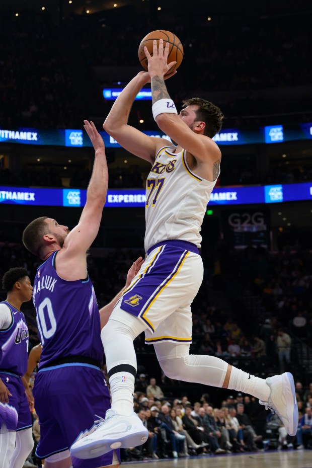 Lakers guard Luka Doncic, right, shoots the ball over Utah...