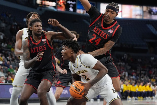 Michigan guard L.J. Cason (2) is pressured by San Diego State guard Taj Degourville (24) and San Diego State forward Pharaoh Compton, left, during the first half of an NCAA college basketball game in Las Vegas, Monday, Nov. 24, 2025. (AP Photo/Eric Gay)