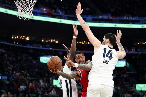 Clippers forward John Collins, center, looks to pass against Memphis...