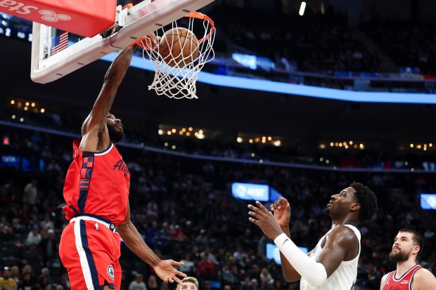 Clippers forward Kawhi Leonard, left, dunks as Memphis Grizzlies forward...