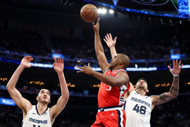 Clippers guard Chris Paul, center, drives to the basket against...