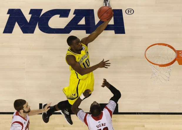 Michigan guard Tim Hardaway Jr. (10) heads to the hoop as Louisville center Gorgui Dieng (10) defends during the second half of the NCAA Final Four tournament college basketball championship game Monday, April 8, 2013, in Atlanta. (AP Photo/David J. Phillip)