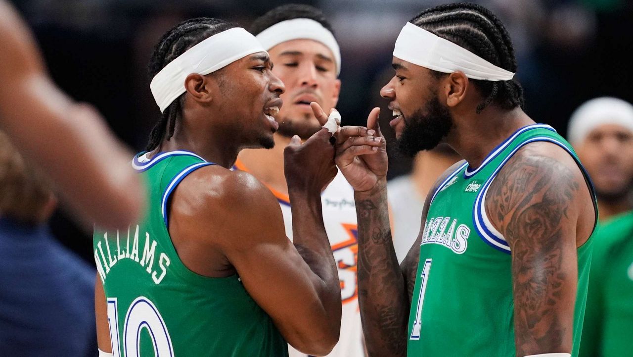 Dallas Mavericks' Brandon Williams (10) and Jaden Hardy, right, celebrate during a time out in the first half of an NBA basketball game against the Phoenix Suns Thursday,Nov. 13, 2025, in Dallas. (AP Photo/Tony Gutierrez)