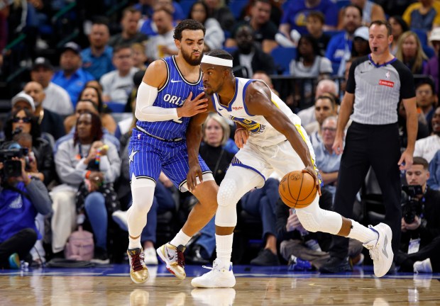 Jimmy Butler III #10 of the Golden State Warriors posts up Tyus Jones #2 of the Orlando Magic in the first half during a game  at Kia Center on Nov. 18, 2025 in Orlando, Florida. NOTE TO USER: User expressly acknowledges and agrees that, by downloading and or using this photograph, User is consenting to the terms and conditions of the Getty Images License Agreement. (Photo by Mike Ehrmann/Getty Images)