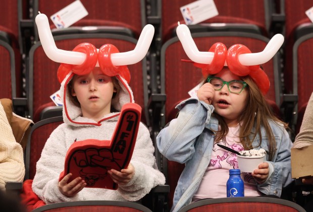 Two young fans wearing balloon horns take their seats for a Bulls-Heat game at the United Center on Nov. 21, 2025, in Chicago. (John J. Kim/Chicago Tribune)