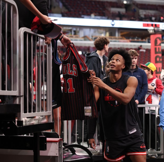 Bulls forward Isaac Okoro signs autographs before a game against the Heat at the United Center on Nov. 21, 2025, in Chicago. (John J. Kim/Chicago Tribune)