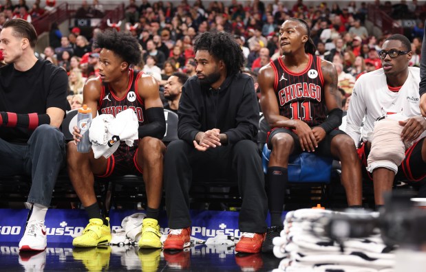 Bulls guard Coby White, center, is dressed in street clothes as he watches the second quarter against the Heat at the United Center on Nov. 21, 2025, in Chicago. (John J. Kim/Chicago Tribune)