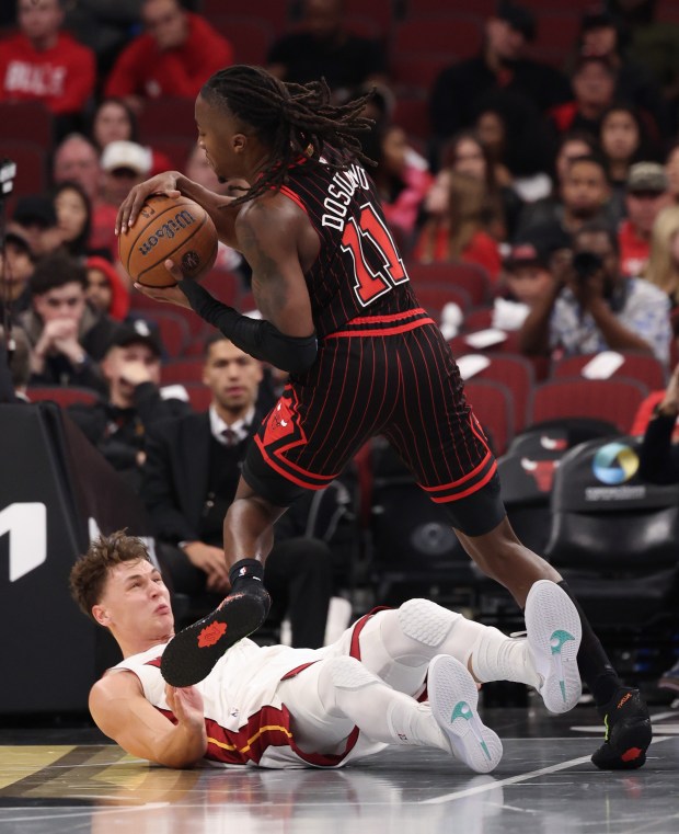Bulls guard Ayo Dosunmu (11) is fouled by Heat guard Pelle Larsson in the fourth quarter at the United Center on Nov. 21, 2025, in Chicago. (John J. Kim/Chicago Tribune)