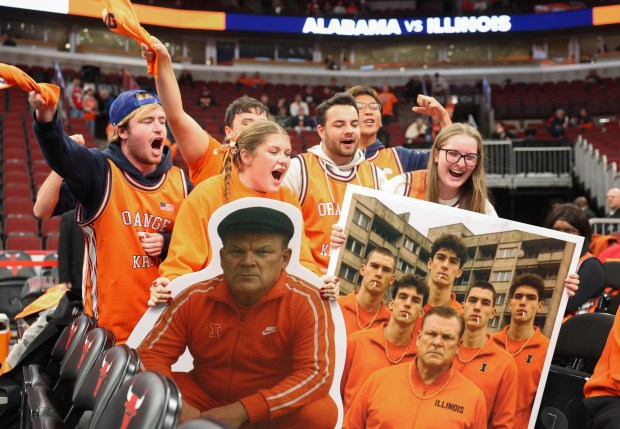Illinois student fans hold a cutout of coach Brad Underwood wearing an eastern European style track suit as they cheer for a broadcast camera before a game against Alabama at the United Center on Nov. 19, 2025. (John J. Kim/Chicago Tribune)