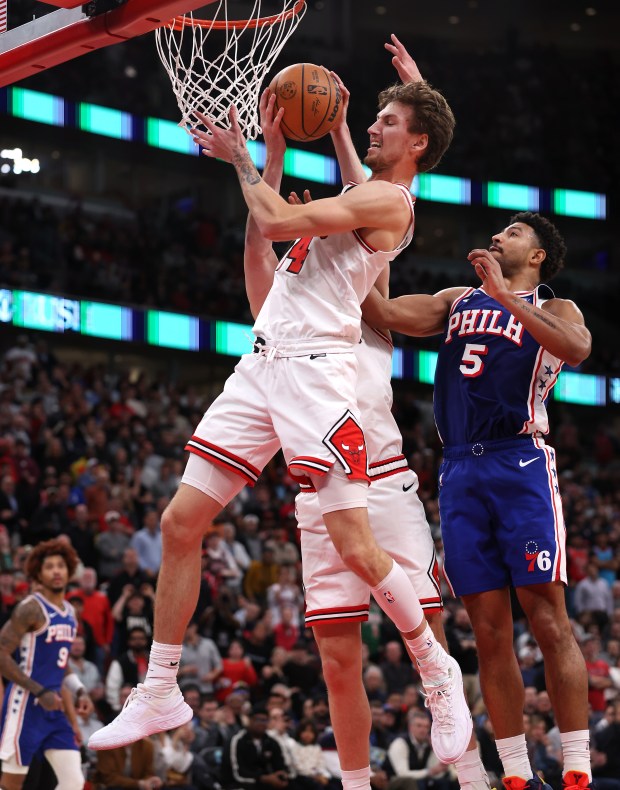 Chicago Bulls forward Matas Buzelis (14) and his teammate Josh Giddey (background) look to secure a rebound in the second half of a game against the Philadelphia 76ers at the United Center in Chicago on Nov. 4, 2025. (Chris Sweda/Chicago Tribune)