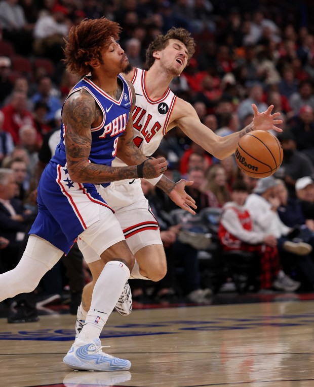 Chicago Bulls forward Matas Buzelis (14) loses the ball while colliding with Philadelphia 76ers forward/guard Kelly Oubre Jr. (9) in the first half of a game at the United Center in Chicago on Nov. 4, 2025. (Chris Sweda/Chicago Tribune)