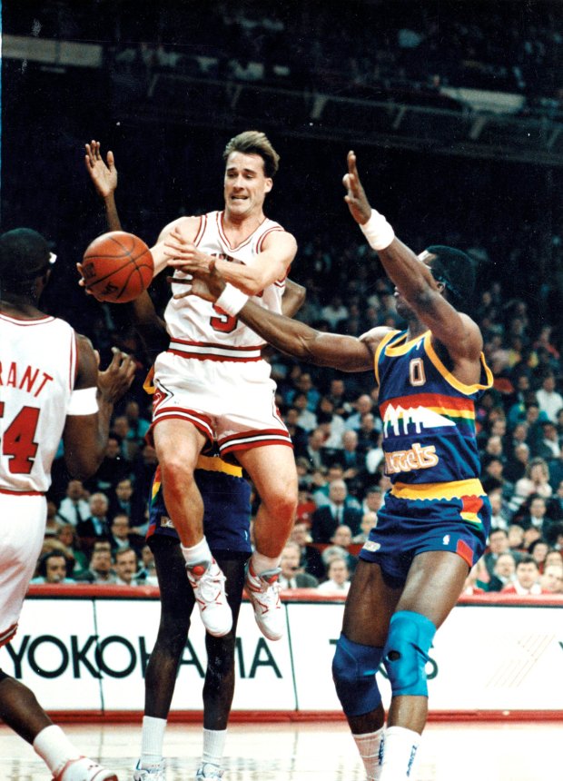 The Bulls' John Paxson goes up for a shot against...