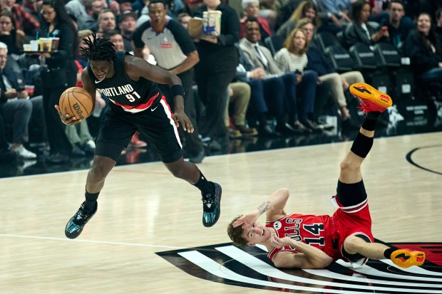Portland Trail Blazers guard Sidy Cissoko, left, is tripped by Chicago Bulls forward Matas Buzelis during the first half of an NBA basketball game in Portland, Ore., Wednesday, Nov. 19, 2025. (AP Photo/Craig Mitchelldyer)