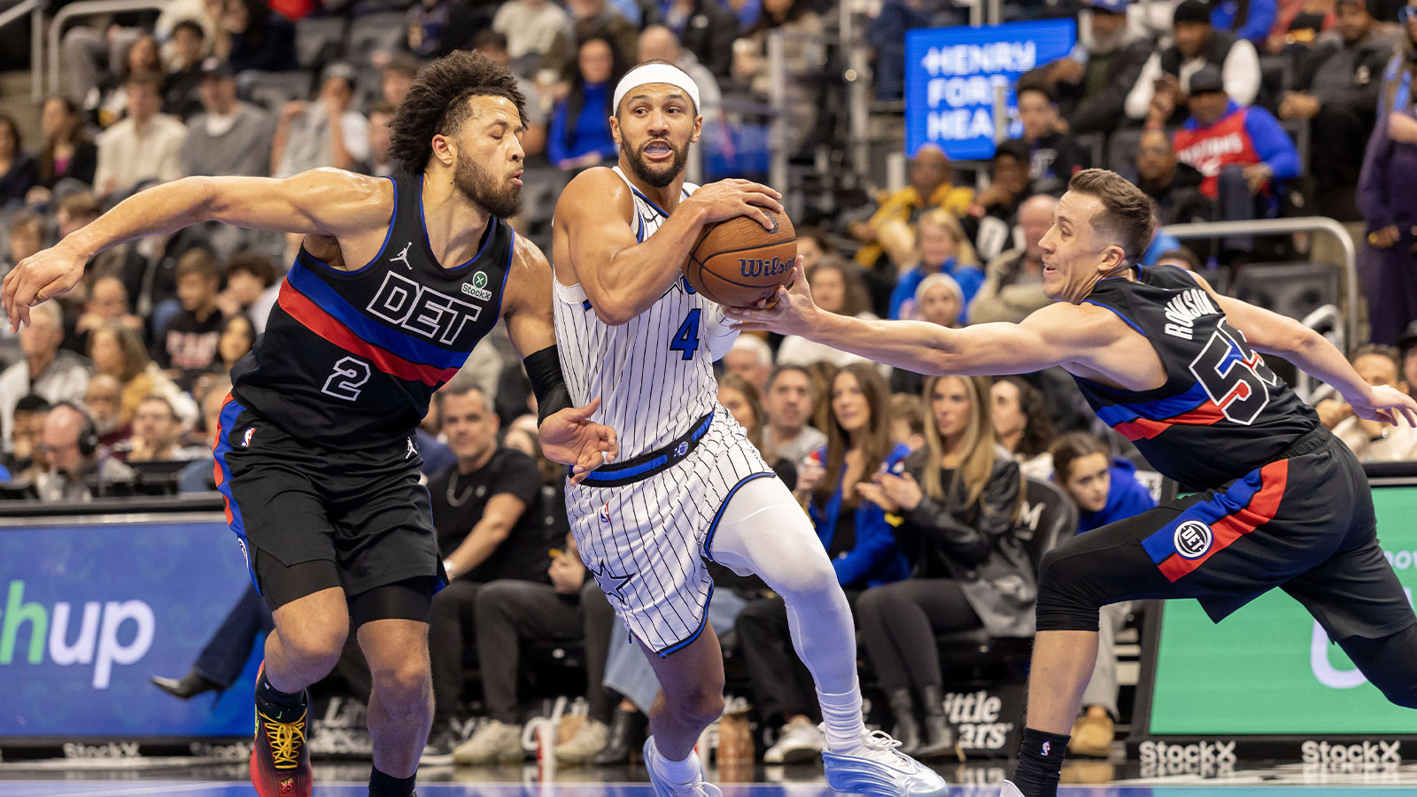 Detroit Pistons guard Cade Cunningham (2) and forward Duncan Robinson (55) defends against Orlando Magic guard Jalen Suggs (4) during the first quarter at Little Caesars Arena.