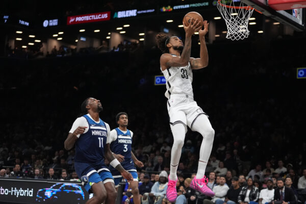 Brooklyn Nets' Nic Claxton (33) drives past Minnesota Timberwolves' Naz Reid (11) and Jaden McDaniels (3) during the first half of an NBA basketball game Monday, Nov. 3, 2025, at Barclays Center in New York. (AP Photo/Frank Franklin II)