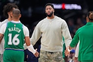 Dallas Mavericks' Anthony Davis, center, greets Caleb Martin (16) and others walking off the...