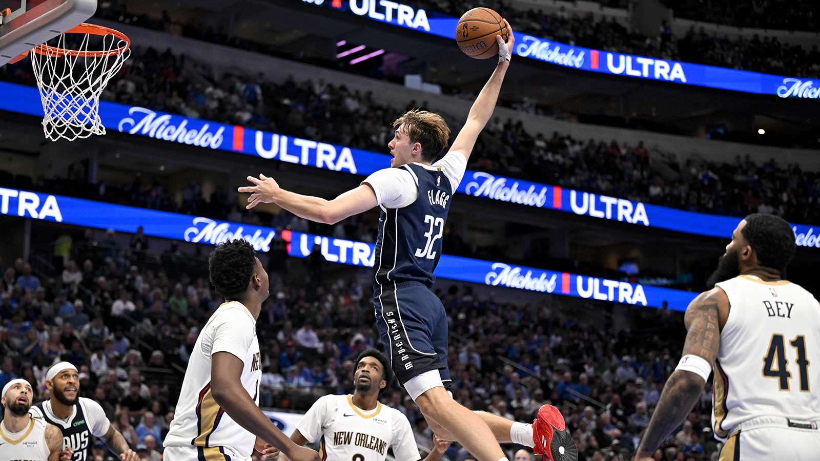 Dallas Mavericks forward Cooper Flagg (32) dunks the ball over New Orleans Pelicans center Derik Queen (22) and forward Herbert Jones (2) during the second half at the American Airlines Center.