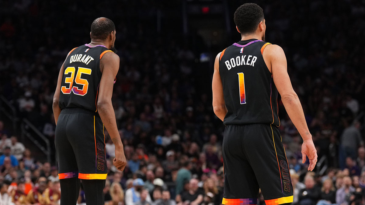 Phoenix Suns forward Kevin Durant (35) and Phoenix Suns guard Devin Booker (1) look on against the Cleveland Cavaliers during the first half at Footprint Center.