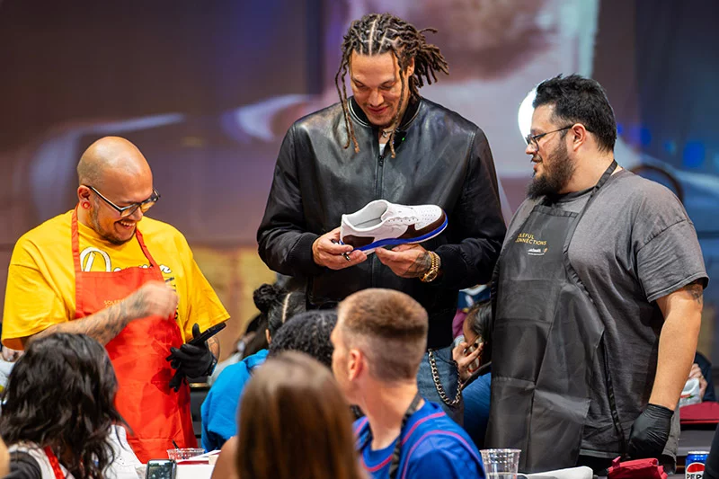 Aaron Gordon checks out a fan's shoe design during Soleful Connections. Clarkson Creative Photography, for UCHealth.