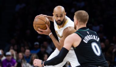 Minnesota Timberwolves' Donte DiVincenzo (0) defends against Boston Celtics' Derrick White (9) during the second half of an NBA basketball game, Saturday, Nov. 29, 2025, in Minneapolis. (AP Photo/Lily Dozier)