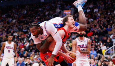 TORONTO, CANADA - OCTOBER 25: Andre Drummond #5 of the Philadelphia 76ers tumbles over the back of Jakob Poeltl #19 of the Toronto Raptors as he looks to take a shot during the second half of their NBA game at Scotiabank Arena on October 25, 2024 in Toronto, Ontario, Canada.