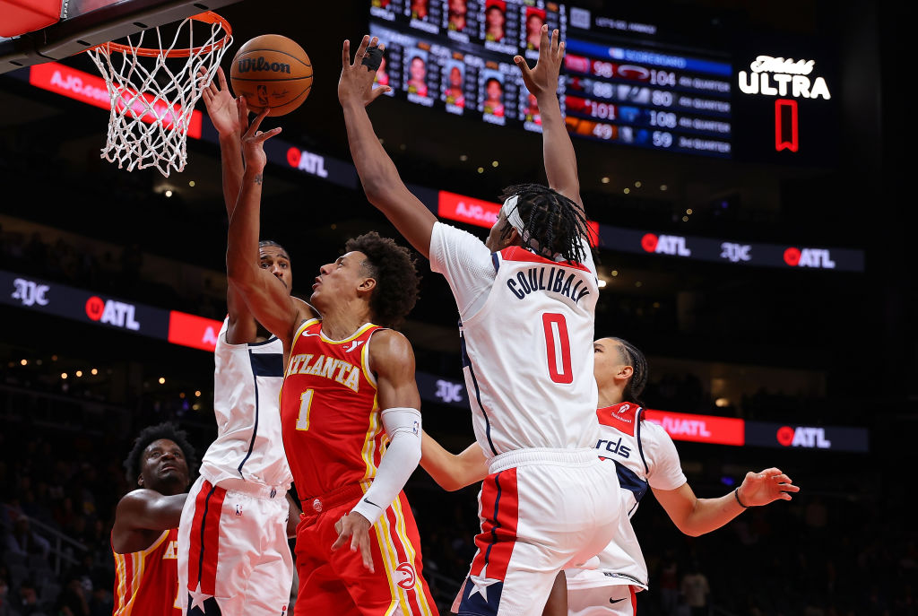ATLANTA, GEORGIA - OCTOBER 28: Jalen Johnson #1 of the Atlanta Hawks draws a foul as he drives against Alexandre Sarr #20, Bilal Coulibaly #0 and Kyshawn George #18 of the Washington Wizards during the fourth quarter at State Farm Arena on October 28, 2024 in Atlanta, Georgia. NOTE TO USER: User expressly acknowledges and agrees that, by downloading and/or using this photograph, user is consenting to the terms and conditions of the Getty Images License Agreement. (Photo by Kevin C. Cox/Getty Images)