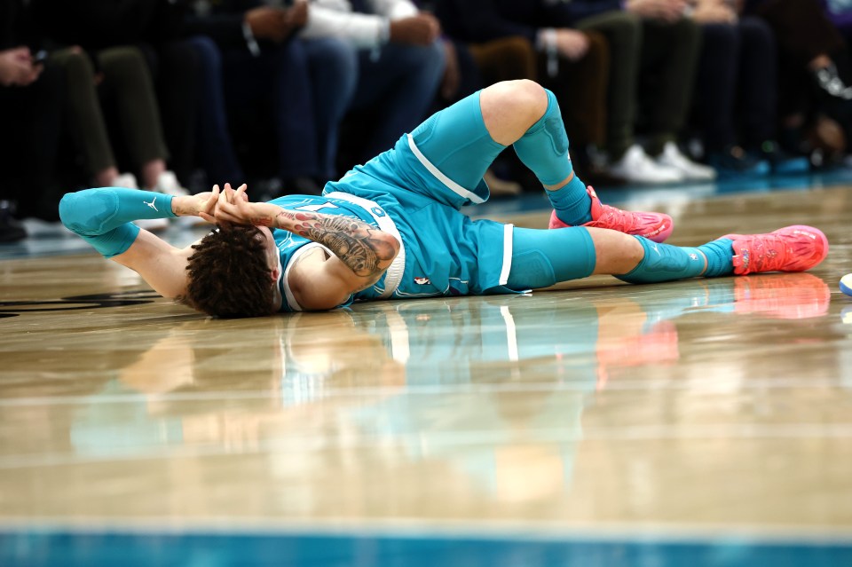 LaMelo Ball falls to the ground following a left ankle sprain after colliding with Jarred Vanderbilt #2 of the Los Angeles Lakers during the second quarter of the game at Spectrum Center on January 27, 2025 in Charlotte, North Carolina