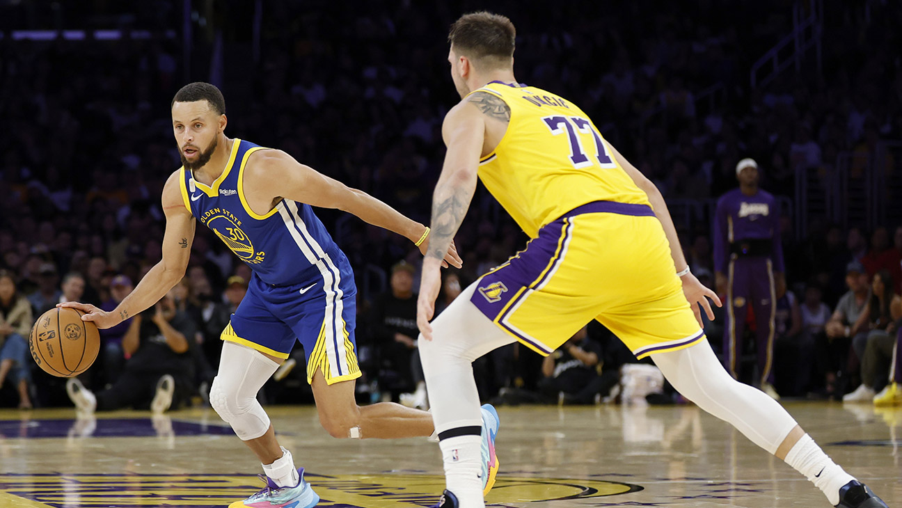 Stephen Curry #30 of the Golden State Warriors dribbles in front of Luka Doncic #77 of the Los Angeles Lakers during a 119-109 Warriors win in the season opening game between the Golden State Warriors and the Los Angeles Lakers at Crypto.com Arena on October 21, 2025 in Los Angeles, California.