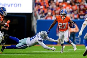DENVER, COLORADO - OCTOBER 26: J.K. Dobbins #27 of the Denver Broncos carries the ball as Donovan Ezeiruaku #41 of the Dallas Cowboys attempts a tackle in the fourth quarter at Empower Field at Mile High on October 26, 2025 in Denver, Colorado. (Photo by Dustin Bradford/Getty Images)