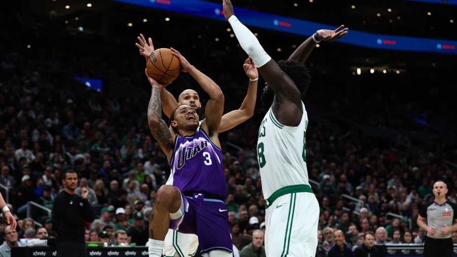 Keyonte George #3 of the Utah Jazz tries to get off a shot over Neemias Queta #88 of the Boston Cel...