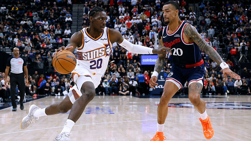Rasheer Fleming #20 of the Phoenix Suns drives to the basket on John Collins #20 of the LA Clippers...