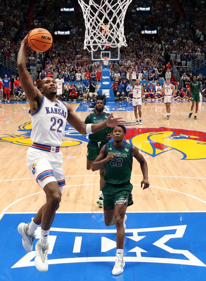 uard Darryn Peterson #22 of the Kansas Jayhawks dunks on a fast break as guard Lebron Thomas #22 of the Green Bay Phoenix chases him down