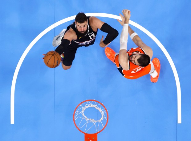Denver Nuggets center Jonas Valanciunas, left, scores around Clippers center...