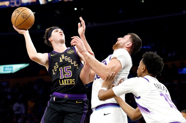 Lakers guard Austin Reaves goes up for a shot as...