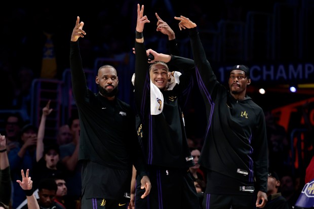Lakers star LeBron James, far left, reacts to a 3-pointer...