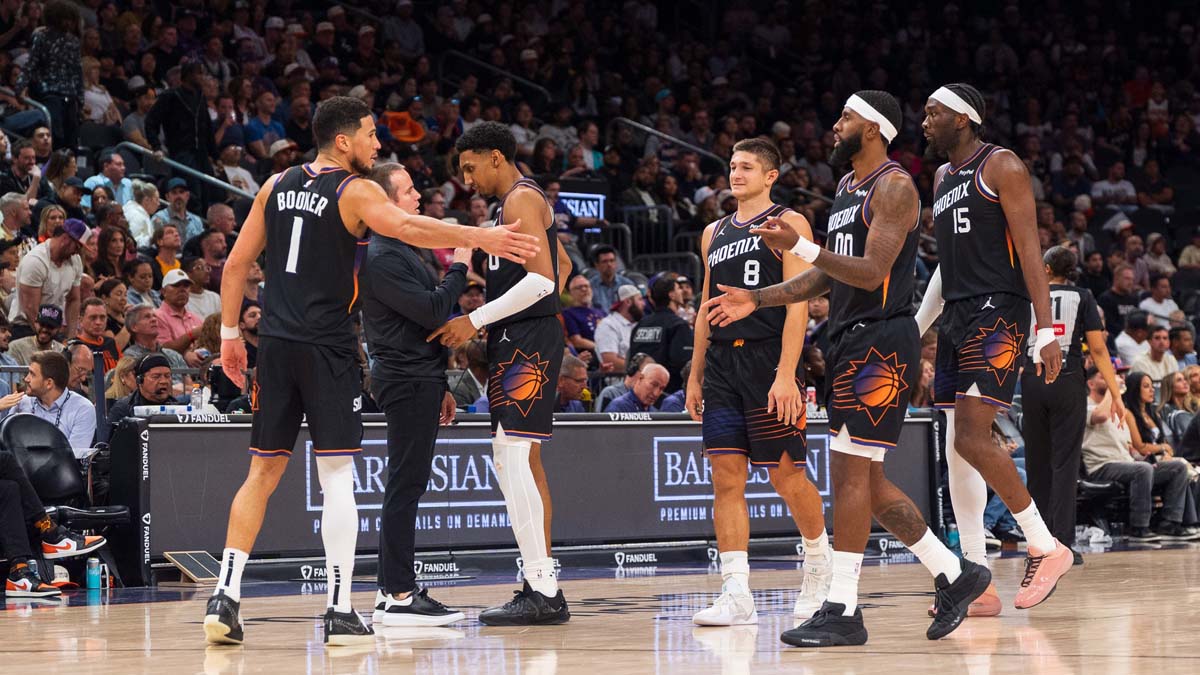 Phoenix Suns guard Devin Booker (1), forward Ryan Dunn (0), Coach Jordan Ott, guard Grayson Allen (8), forward Royce O'Neale (00) and center Mark Williams (15) celebrate during a time-out in the second half against the San Antonio Spurs at Mortgage Matchup Center.