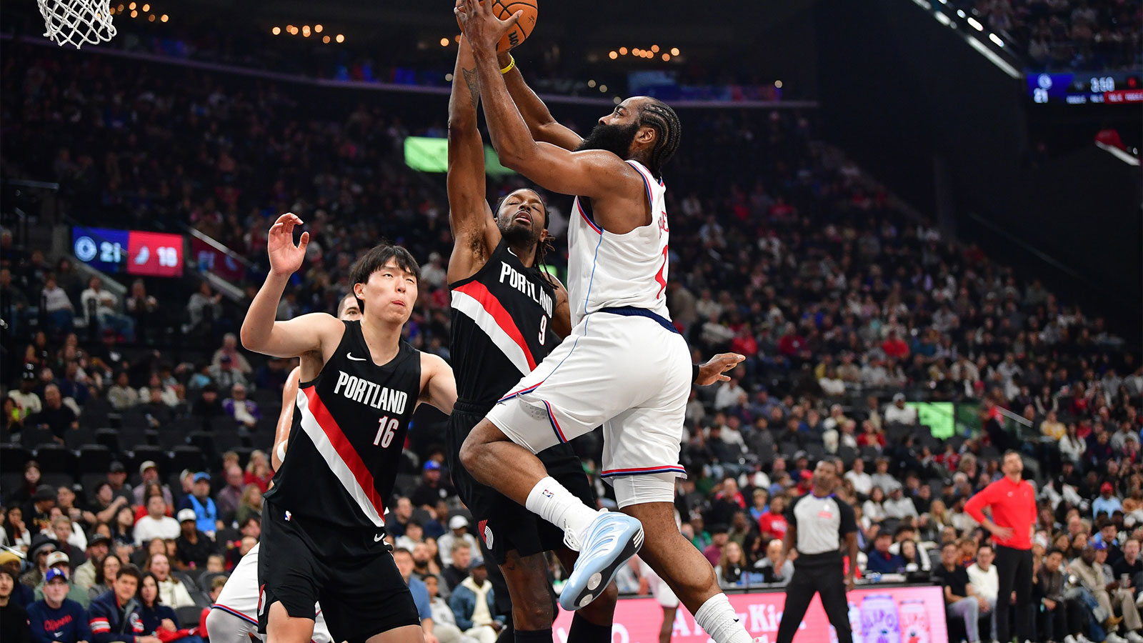 Los Angeles Clippers guard James Harden (1) moves to the basket against Portland Trail Blazers center Yang Hansen (16) and forward Jerami Grant (9) during the first half at Intuit Dome. 
