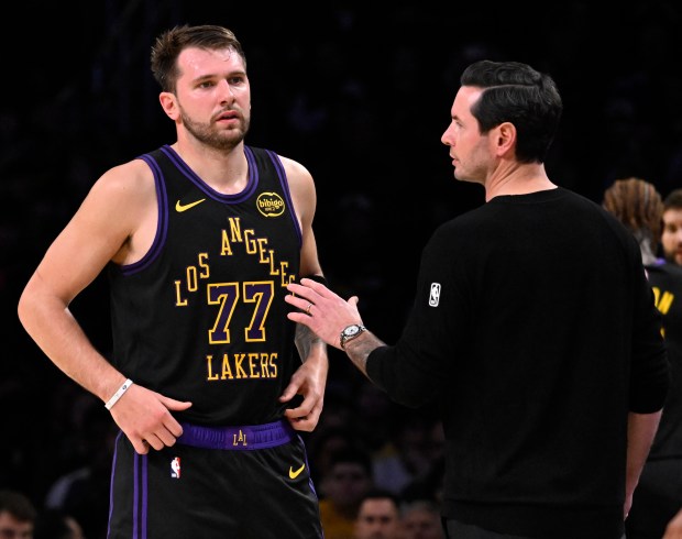 Lakers head coach JJ Redick speaks with star guard Luka...