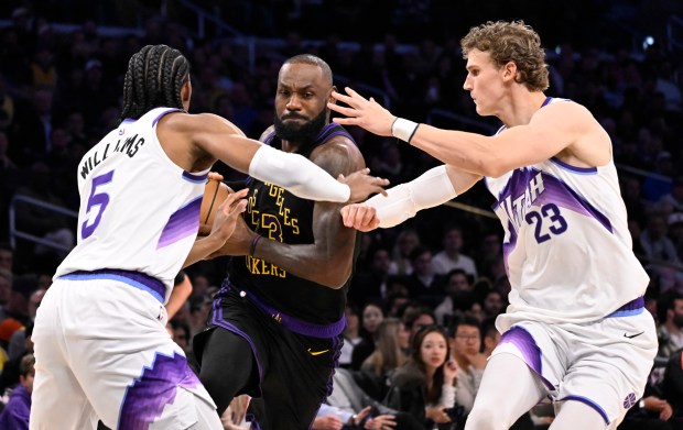 Lakers star LeBron James drives to the basket between the...