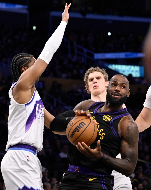 Lakers star LeBron James drives to the basket between the...