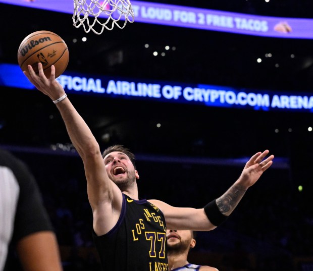 Lakers star Luka Doncic gets to the basket for a...