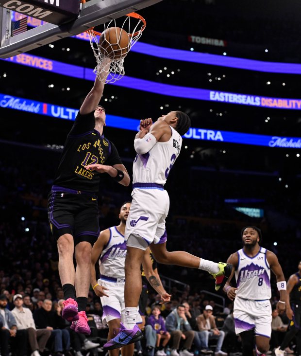 Lakers forward Jake LaRavia, left, dunks in front of the...