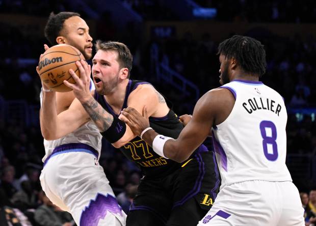Lakers star Luka Doncic drives to the basket between the...